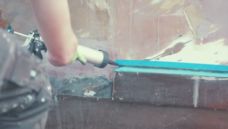 applying sealant to a wood boat rubbing strake