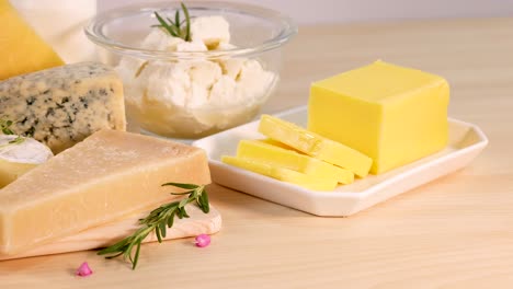 varios quesos y mantequilla en una mesa de madera
