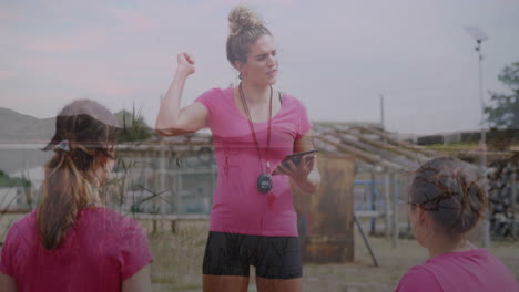 instructing team outdoors, coach in pink shirt with whistle and tablet