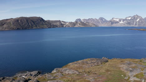 Slow-reveal-over-cliff-side-shows-beautiful-mountain-ranges-in-the-distance