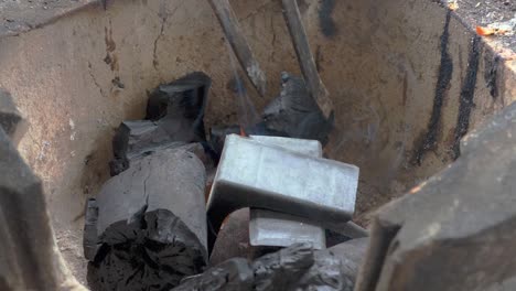 igniting clay furnace with hot and smoking charcoal pieces, handheld view