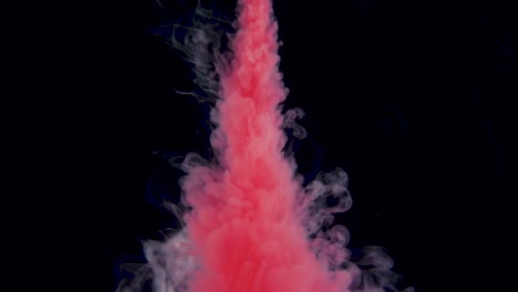 verdadera pintura roja disparada cae en el agua. tinta girando bajo el agua. nube de colisión de tinta aislada en fondo negro. vista de cerca