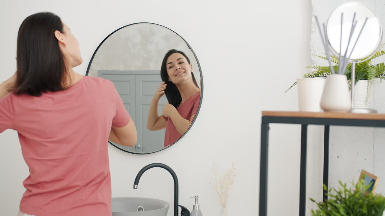 mujer cepillando el cabello en el baño