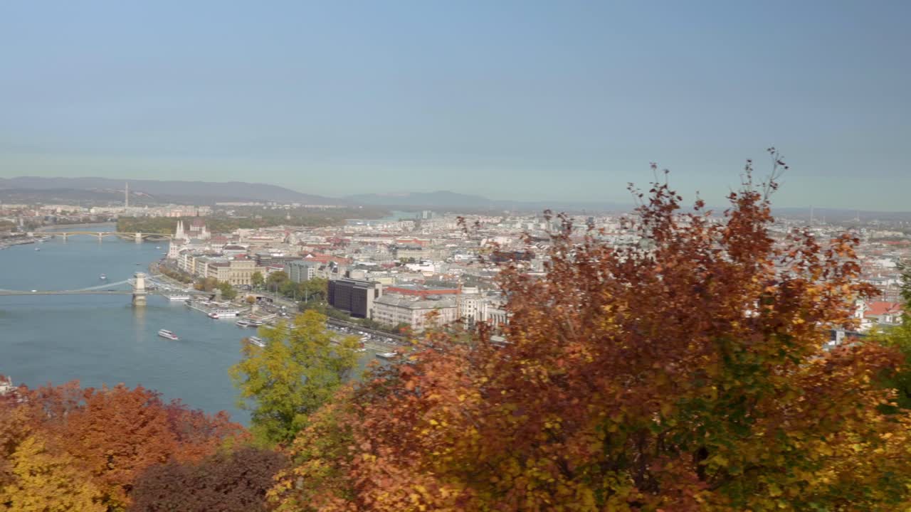 Pan to the left from autumn trees to Budapest from Buda Gell&eacute;rt Hill