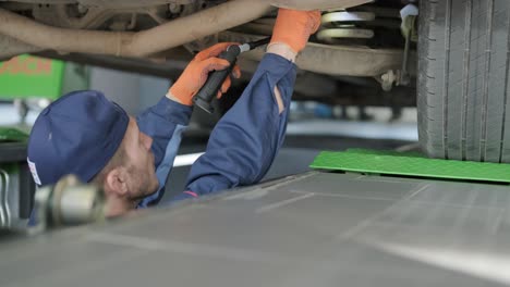 car mechanic working underneath a vehicle