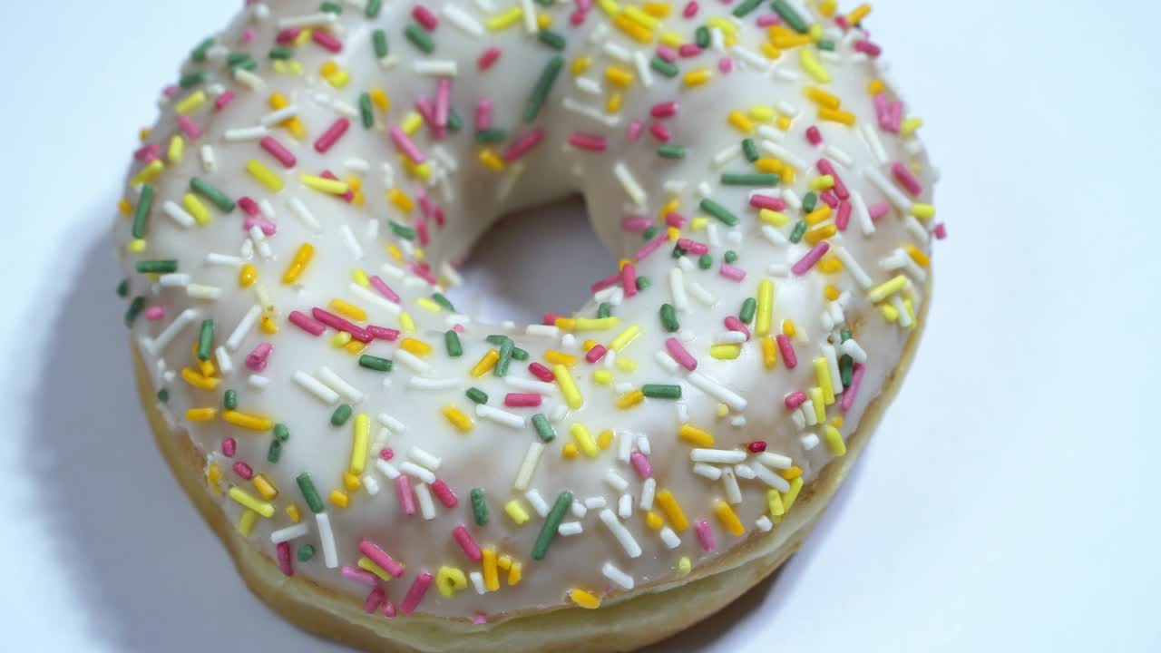 сладкие пончики, вращающиеся на белом фоне. традиционная американская сладость