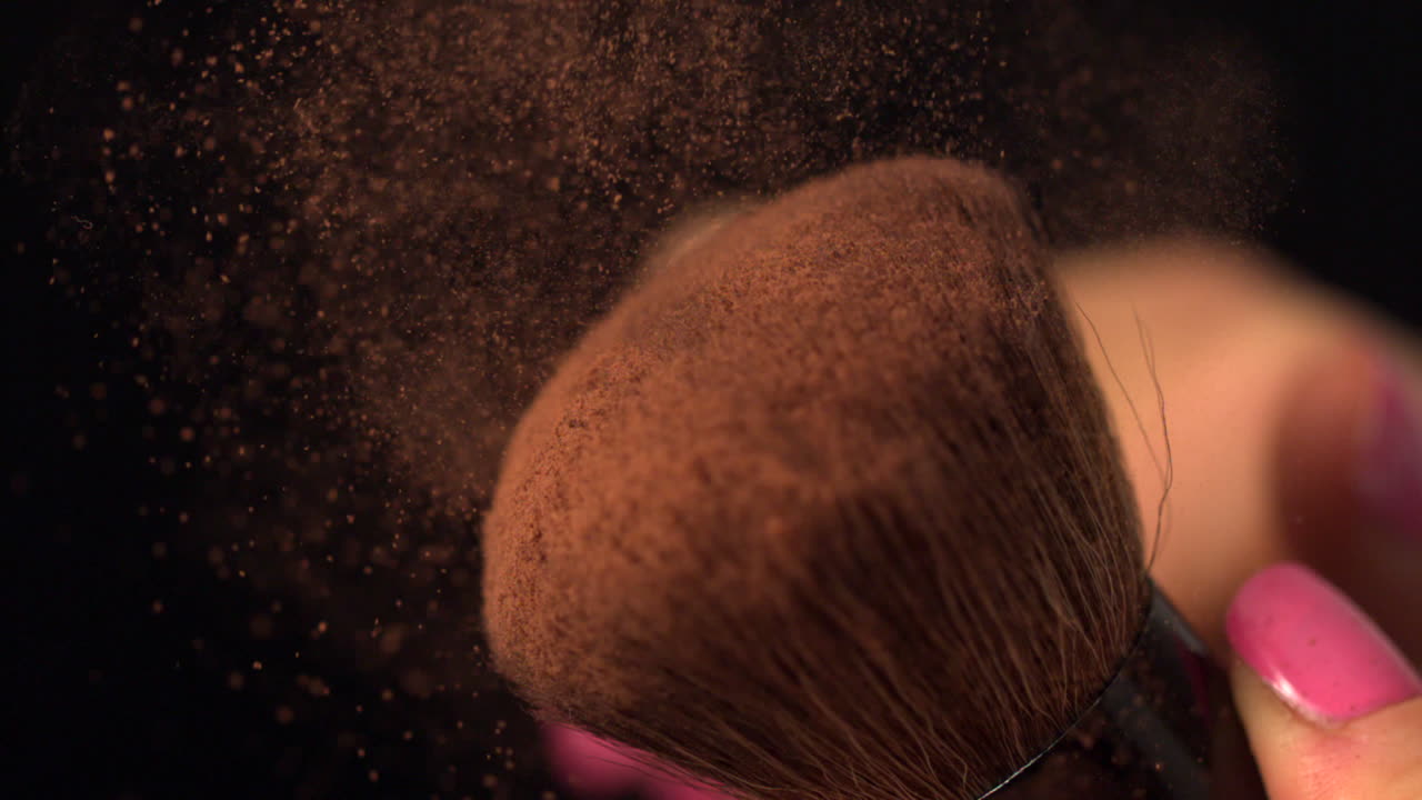 Womans finger running over powder brush