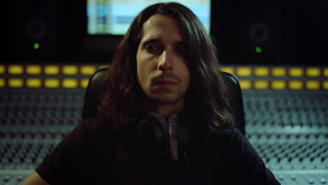 Young-man-listening-music-indoor.-Guy-looking-to-camera-in-music-studio.