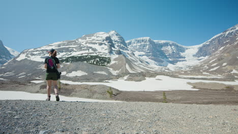 woman enjoys breathtaking scenery of icefield park in canadian rockies