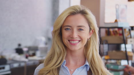 portrait of smiling female owner or worker in coffee shop