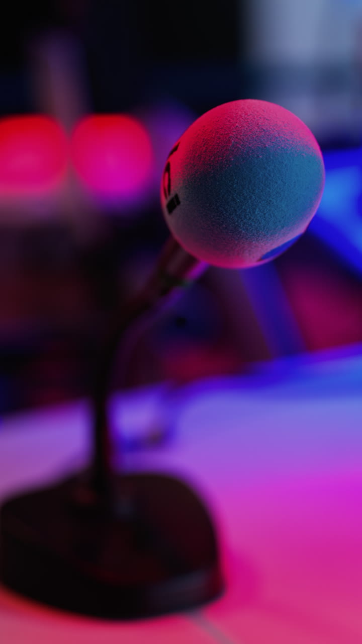 Close up of a microphone on a blurred background with blue and red lights at the International Games Festival in Cannes, France. Vertical