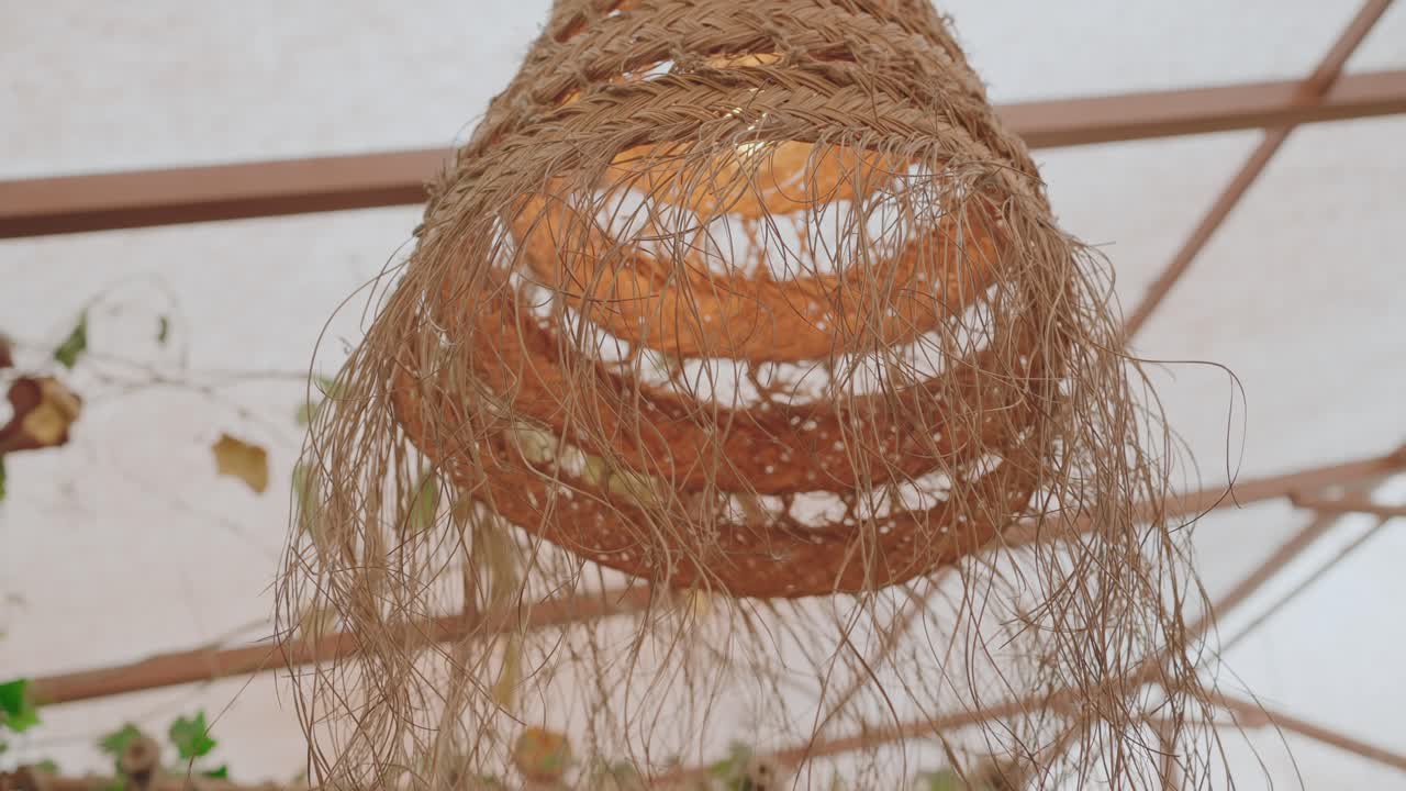 Close up of a woven rustic lamp made from natural fibers