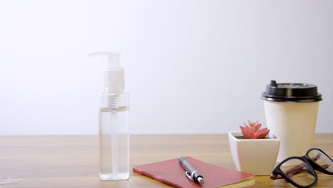 Person-sanitizing-his-hand-with-alcohol-gel-that-is-on-the-office-desk