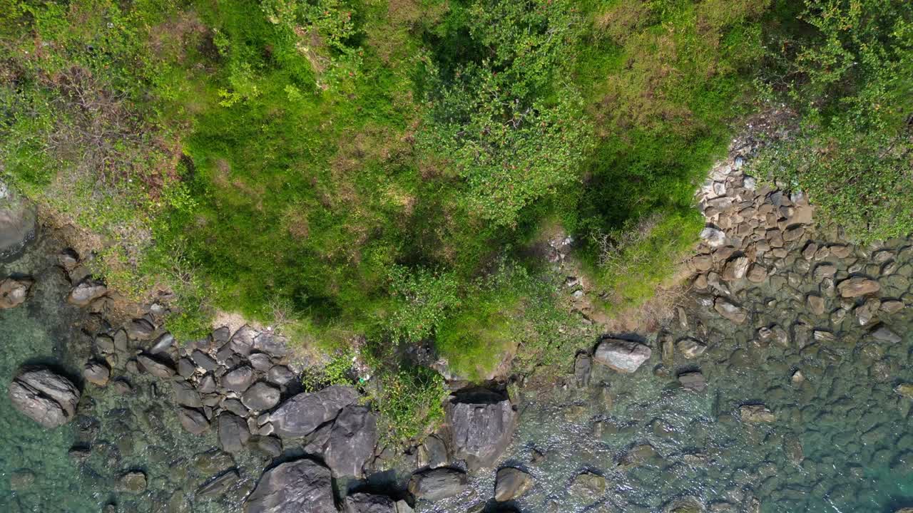 Lush green hills and turquoise waters along Koh Chang's coastline. Amazing aerial view flight vertical bird's eye view drone