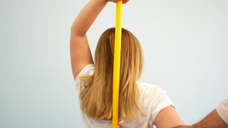 blonde woman doing arm mobility exercises with physiotherapy instructor