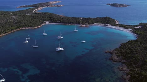 yates caros amarrados en la bahía de color esmeralda en la isla de caprera, cerdeña, italia