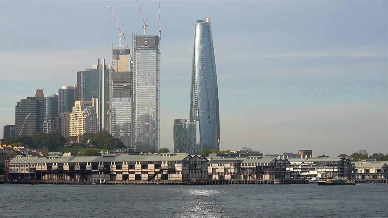 페리가 호주 시드니 하버의 고층 건물을 지나고 있습니다.