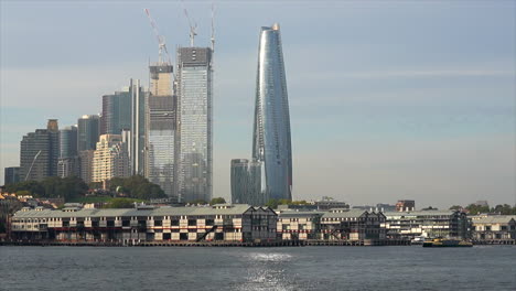 a ferry passes by skyscrapers in sydney harbour, australia