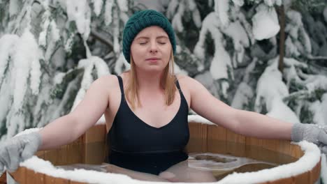 caucasian woman during the winter bath in tube outdoors.