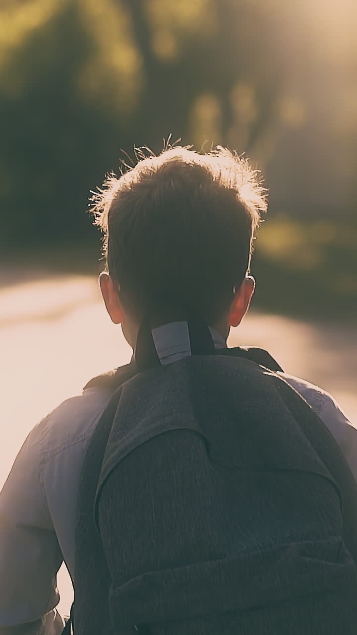 running schoolboy with schoolbag throws away white paper sheets after difficult exam slow motion close backside view