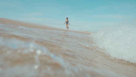 woman walking on a beach, enjoying the waves