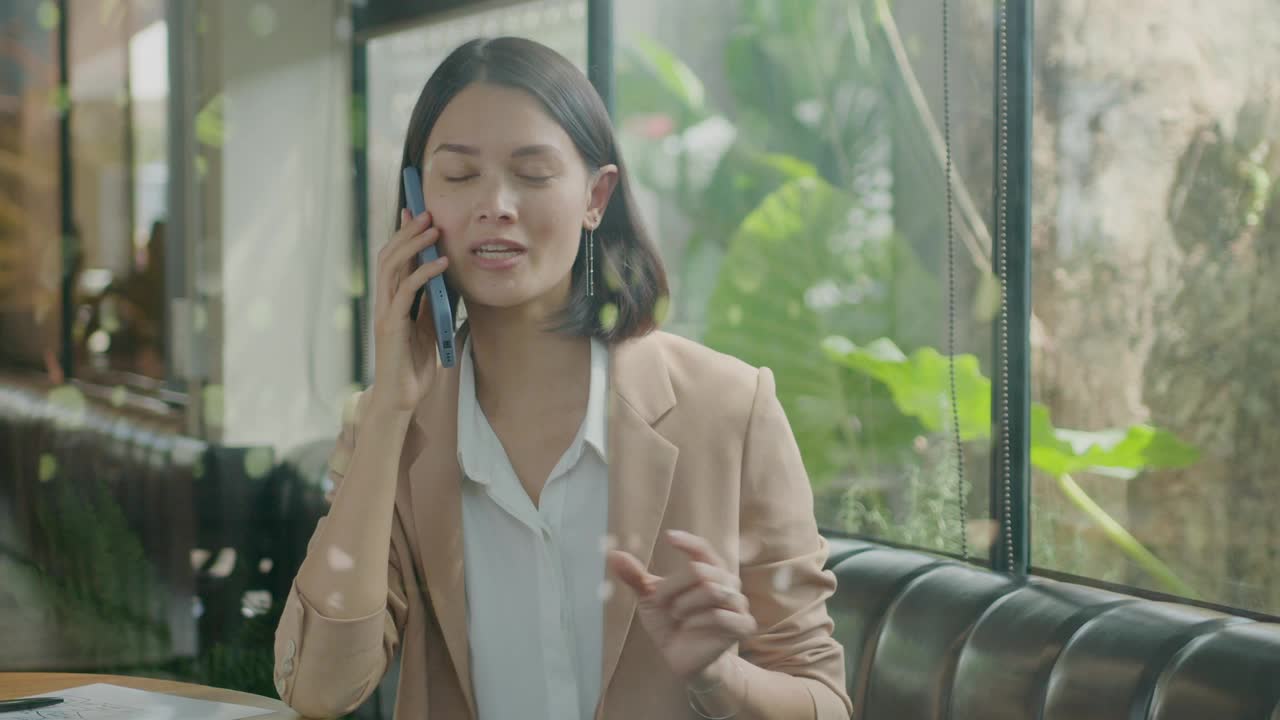 Entrepreneur Discussing Business Plan on Phone in Cafe