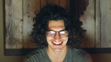 young caucasian man wearing glasses laughing on a video call