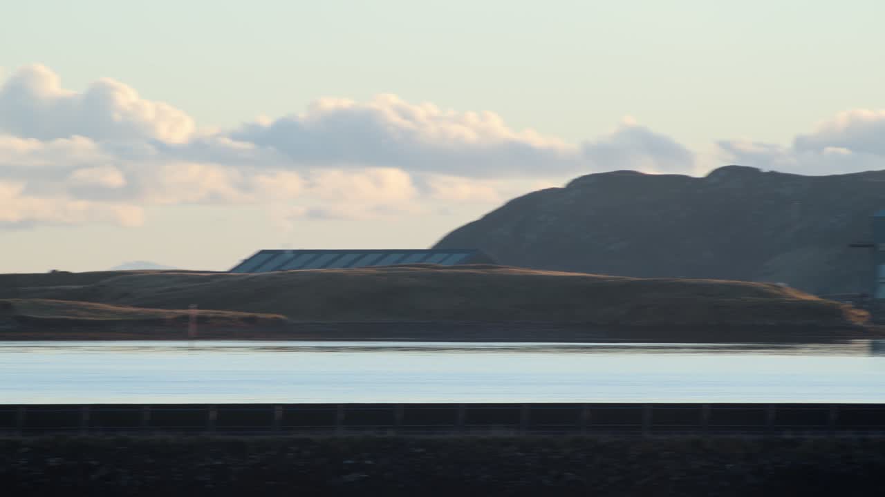 Bild tagen under gyllene timmen av en fyr och en tillverkningsanläggning i Stornoway