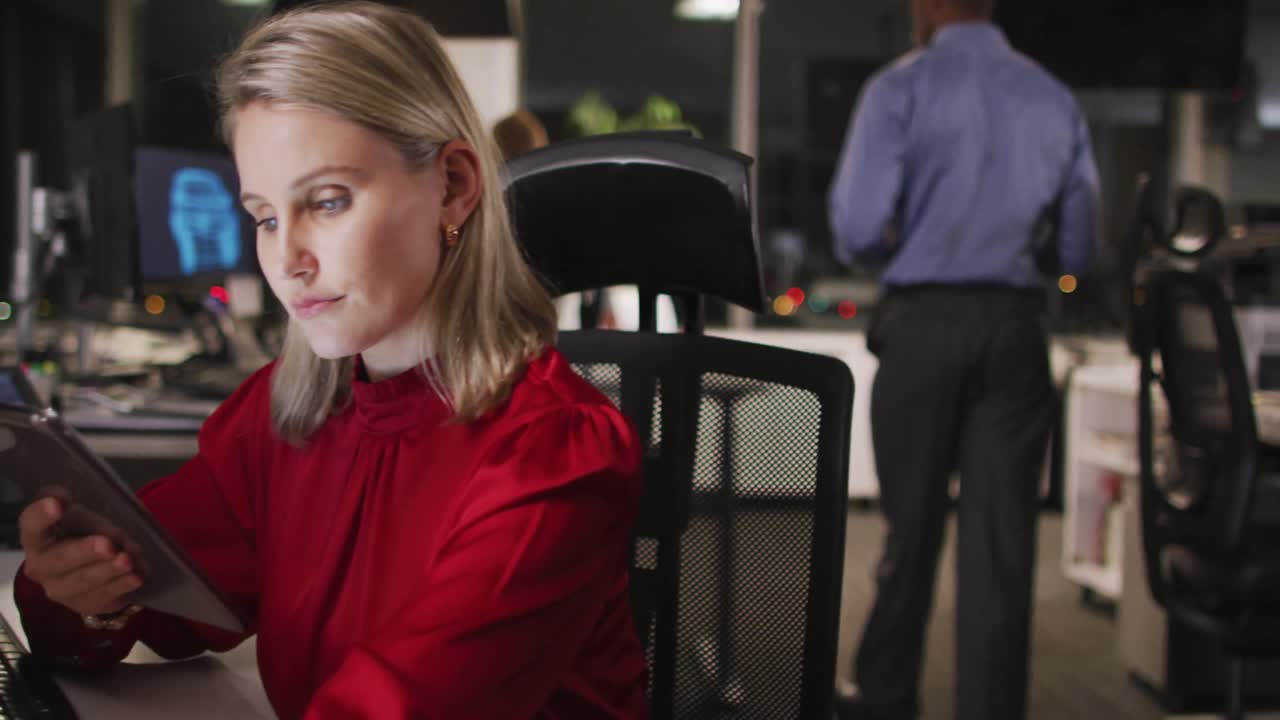 느린 m에서 현대 사무실에서 그녀의 책상에 앉아있는 동안 디지털 태블릿을 사용하는 전문 사업가