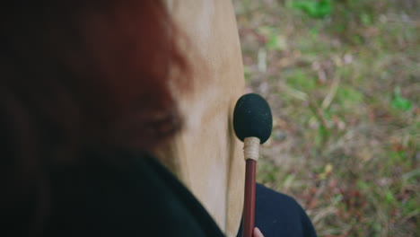 Niña-Druida-En-Un-Bosque-Tocando-Un-Tambor-Chamánico-Detalle-De-ángulo-Alto-Primer-Plano