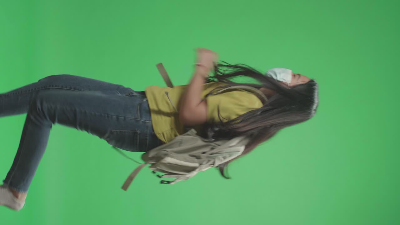 vista lateral de una estudiante asiática con máscara y corriendo a la escuela en pantalla verde clave de croma
