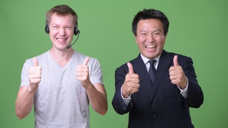 mature japanese businessman and young scandinavian man worker together
