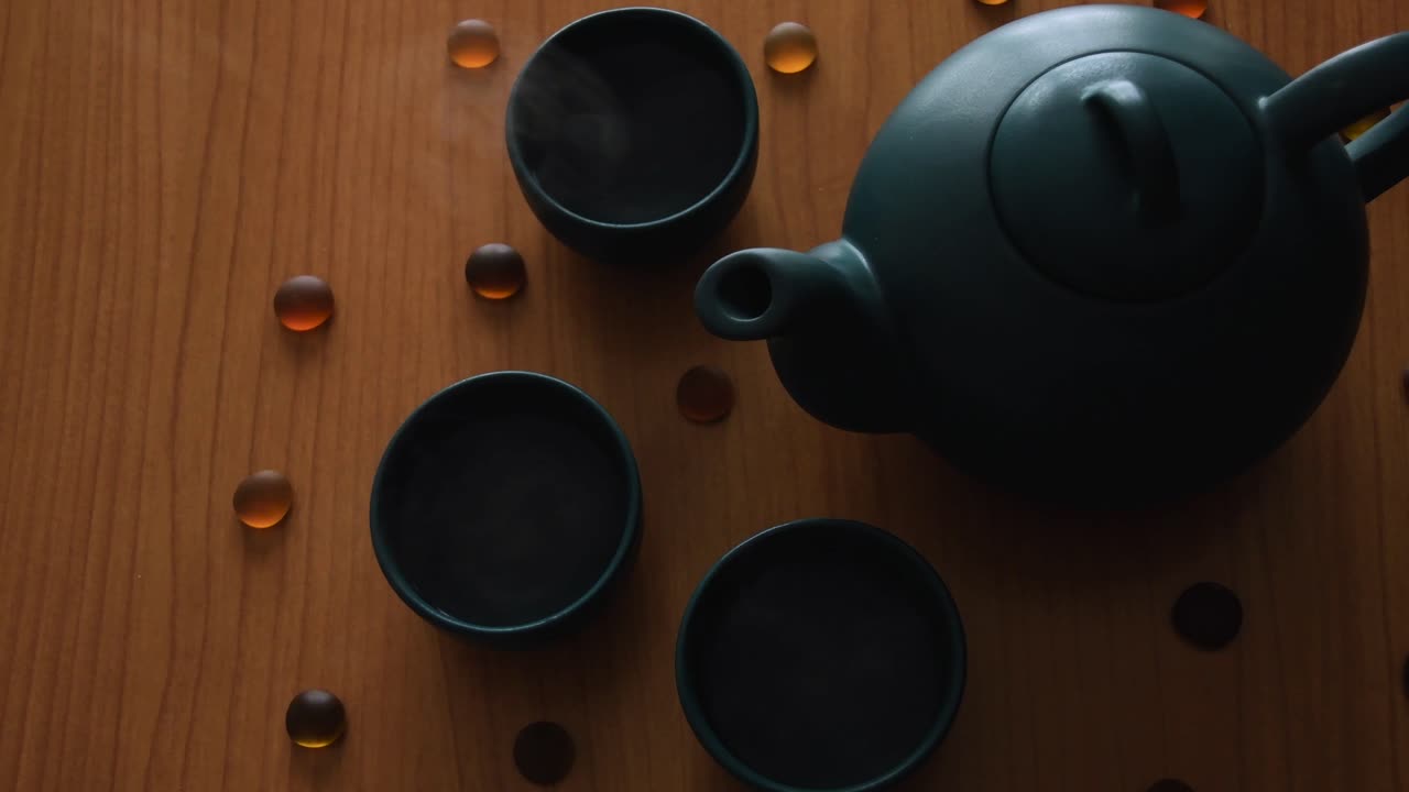 fondo mínimo de un juego de té verde japonés con vapor saliendo de las tazas, sobre una mesa de madera, con algunas piedras alrededor