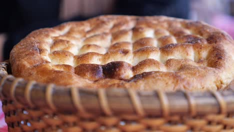 freshly baked flatbread in a rustic basket with a hand touching it