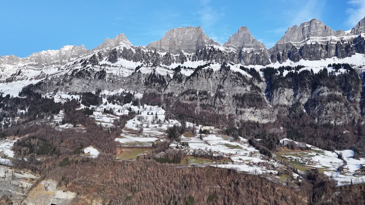 Snow-covered mountain ridges of Churfirsten on a sunny day. Alpine landscape above Walensee near Walenstadt, Switzerland