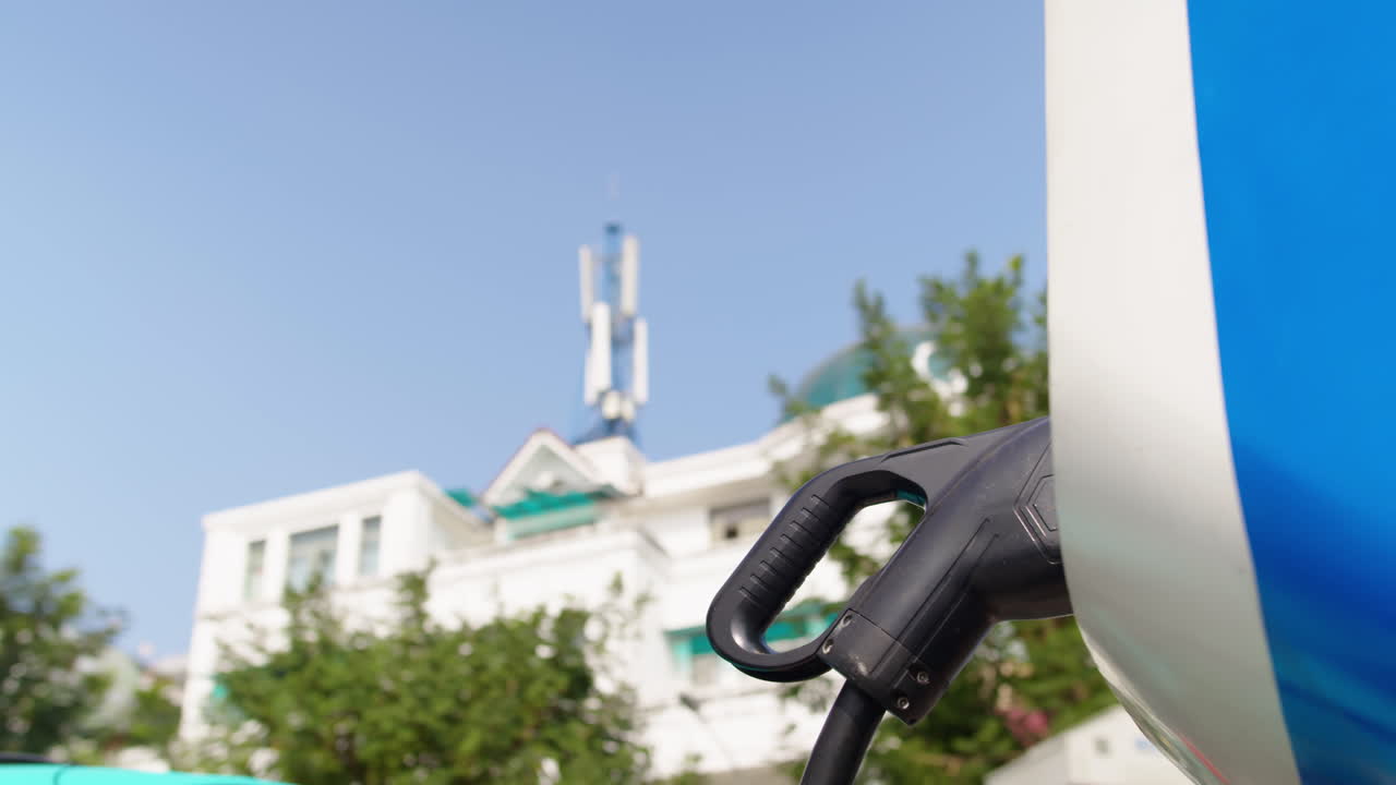 A man charging an electric vehicle at a charging station