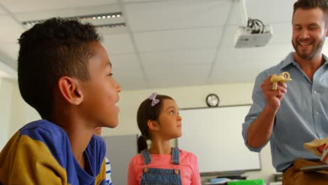 Adult-Caucasian-male-teacher-explaining-anatomical-model-in-classroom-at-school-4k