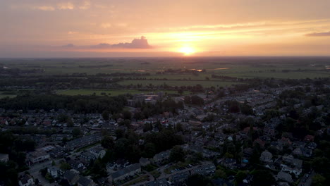 Aerial-of-distant-truck-driving-over-road-through-beautiful-rustic-town-at-sunrise