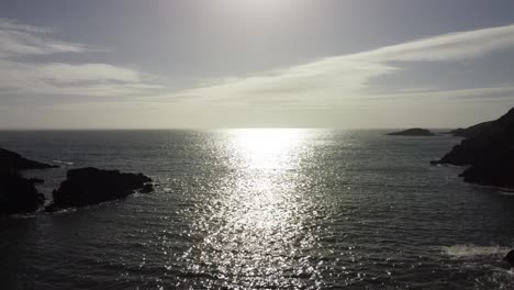 Sun-Reflection-Over-Calm-Ocean-with-Rocky-Coastline