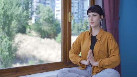 Mujer-Joven-En-Meditación-Frente-A-La-Ventana.