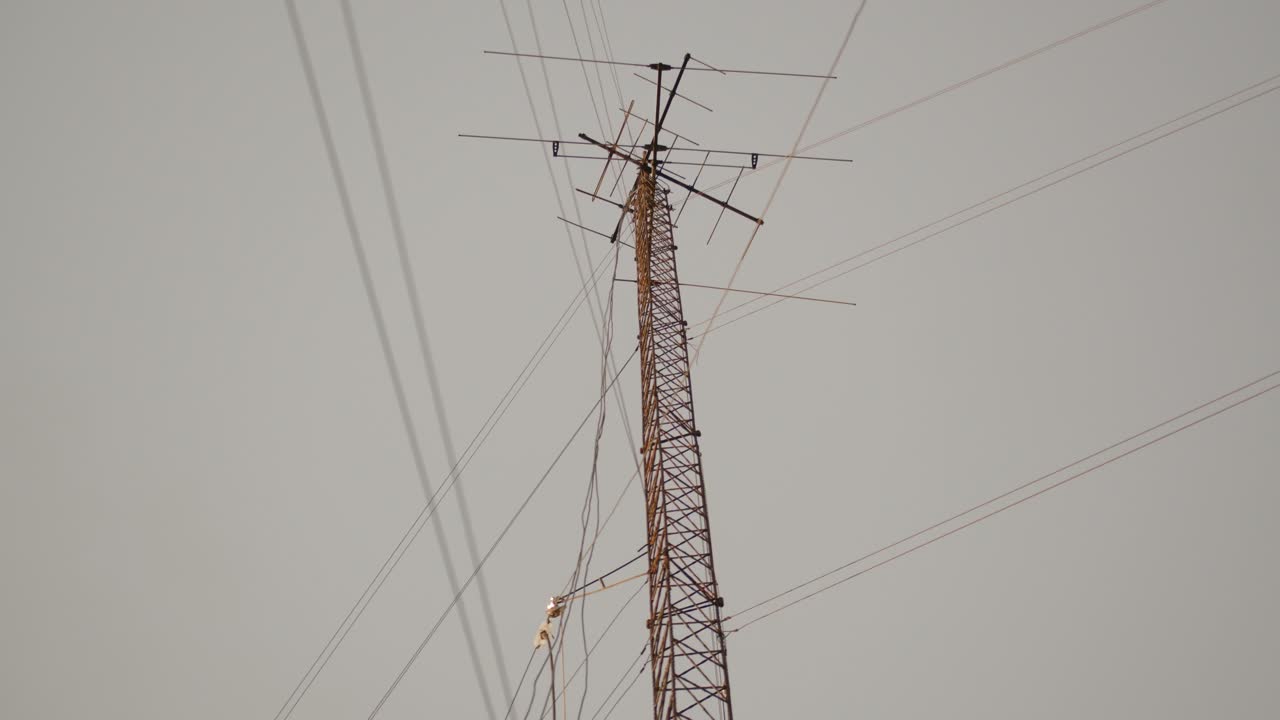 Tall 5G cell tower with multiple antennas against a gray sky in Buenos Aires at dusk