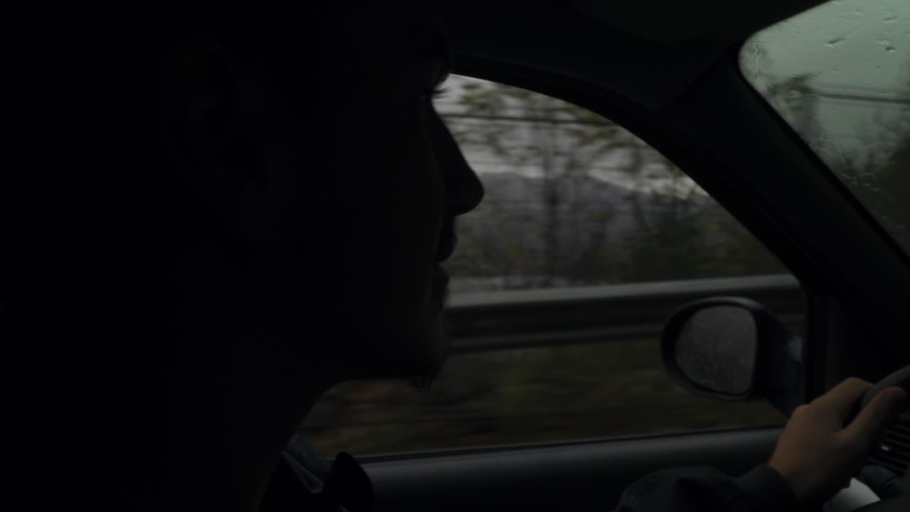 우울한 날 창가에서 밖을 재빨리 훑어보는 차를 운전하는 남자 - 클로즈업 샷