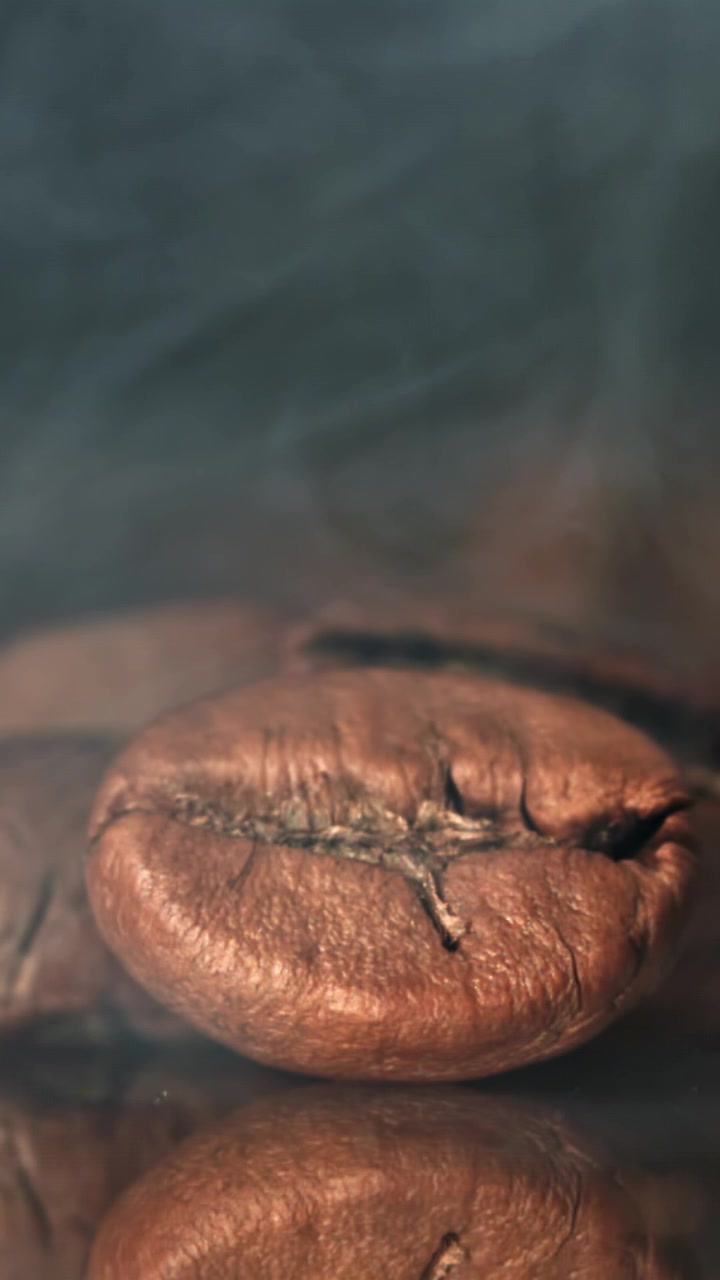 Macro di un chicco di caffè tostato fumante con riflesso