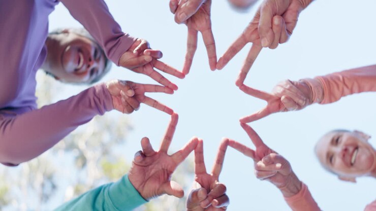 Grupo de idosos fazendo o sinal da paz juntos