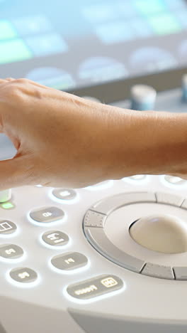 hand of female doctor work at ultrasound machine. medic performs sonography examination of a patient. close up. vertical video