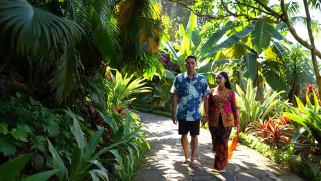 couple strolling through a lush tropical garden