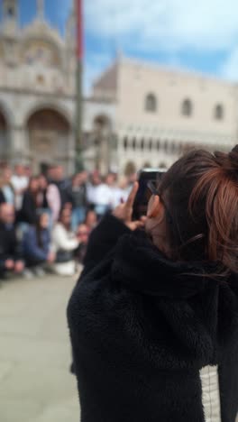 mujer tomando una foto en la plaza de san marcos, venecia