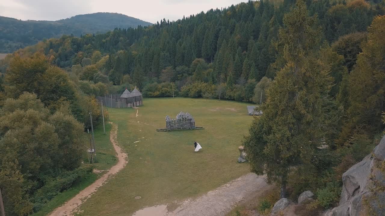 Nygifte løber mod hinanden. Brudgom og brud. Luftfoto