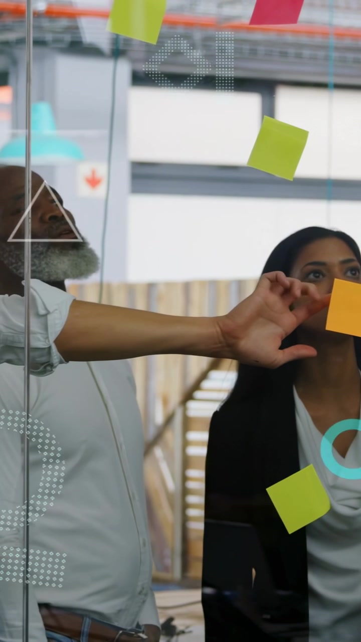 Vertical video: Man reaching glass for orange note, woman moving notes for business using dots