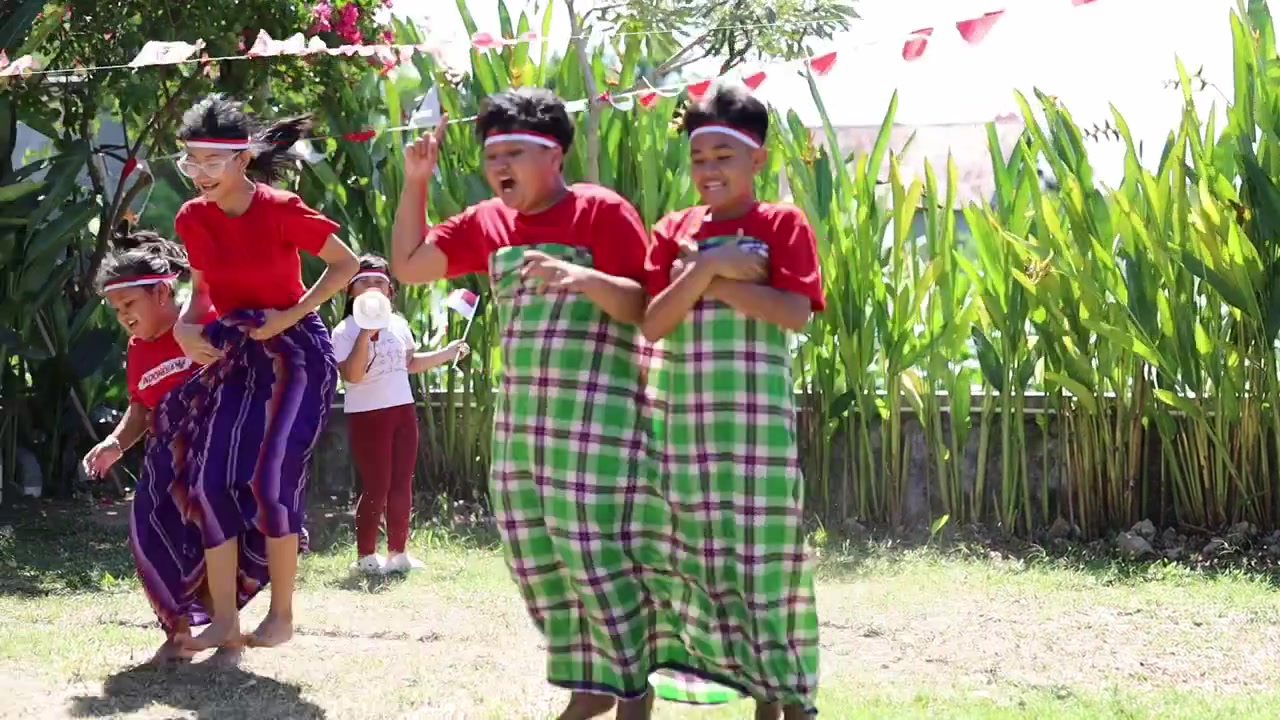 Anak-anak Indonesia merayakan Hari Kemerdekaan Indonesia dengan lomba luar ruangan, balap sarung